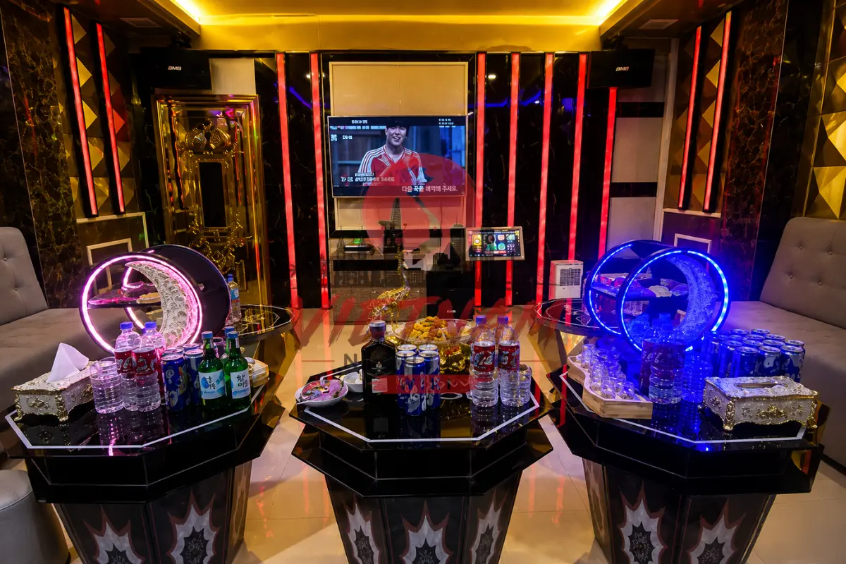 업타운 가라오케 VIP 룸 세팅 — LED 달모양 양주 랙과 팔각 대리석 테이블, 참이슬 소주 및 맥주 세트