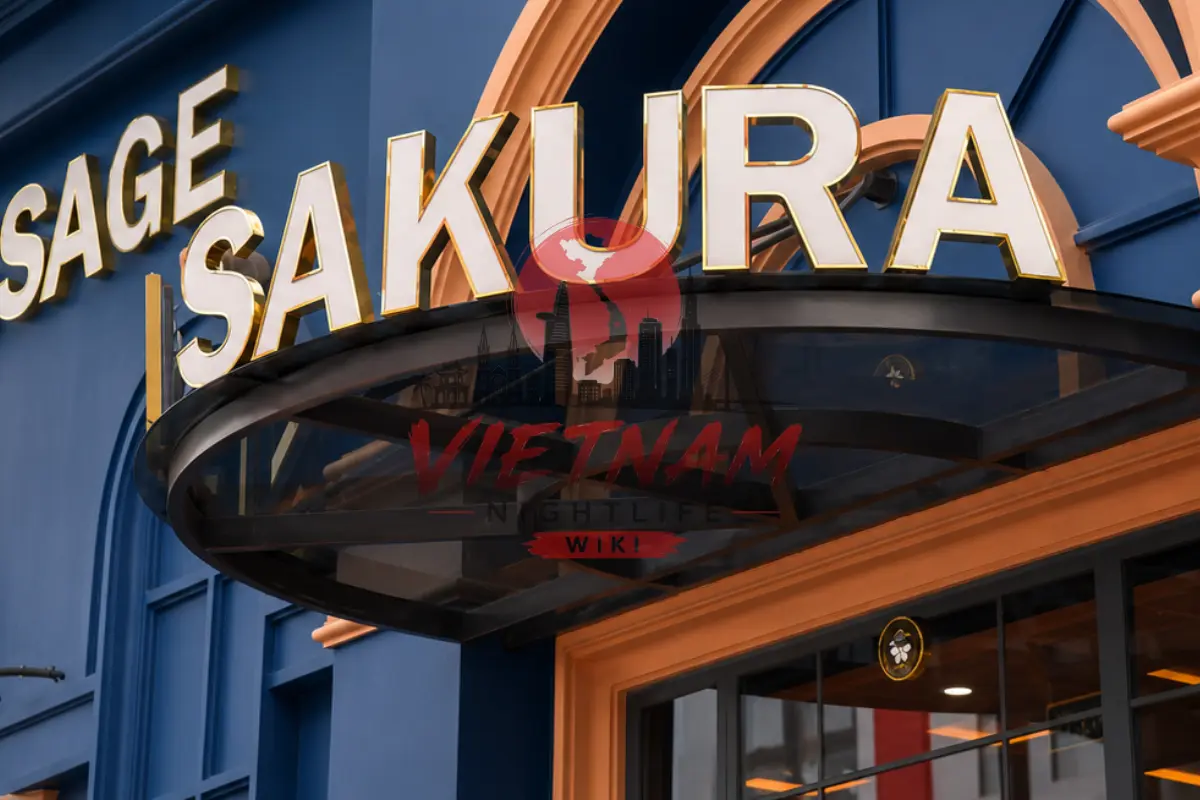 다낭 뉴 사쿠라 마사지 본관 매장 입구 외경 — 네이비 톤 목재 아치 파사드와 금빛 SAKURA MASSAGE 양각 간판
