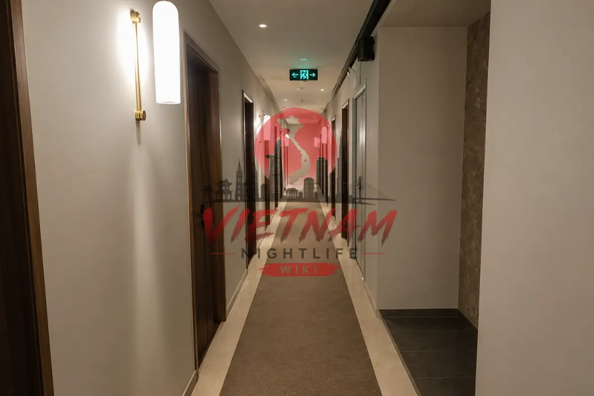 다낭 수 사우나 프라이빗 룸 층별 복도 복도 전경 — 브라운 톤 도어와 미니 벽 sconce 조명 인테리어